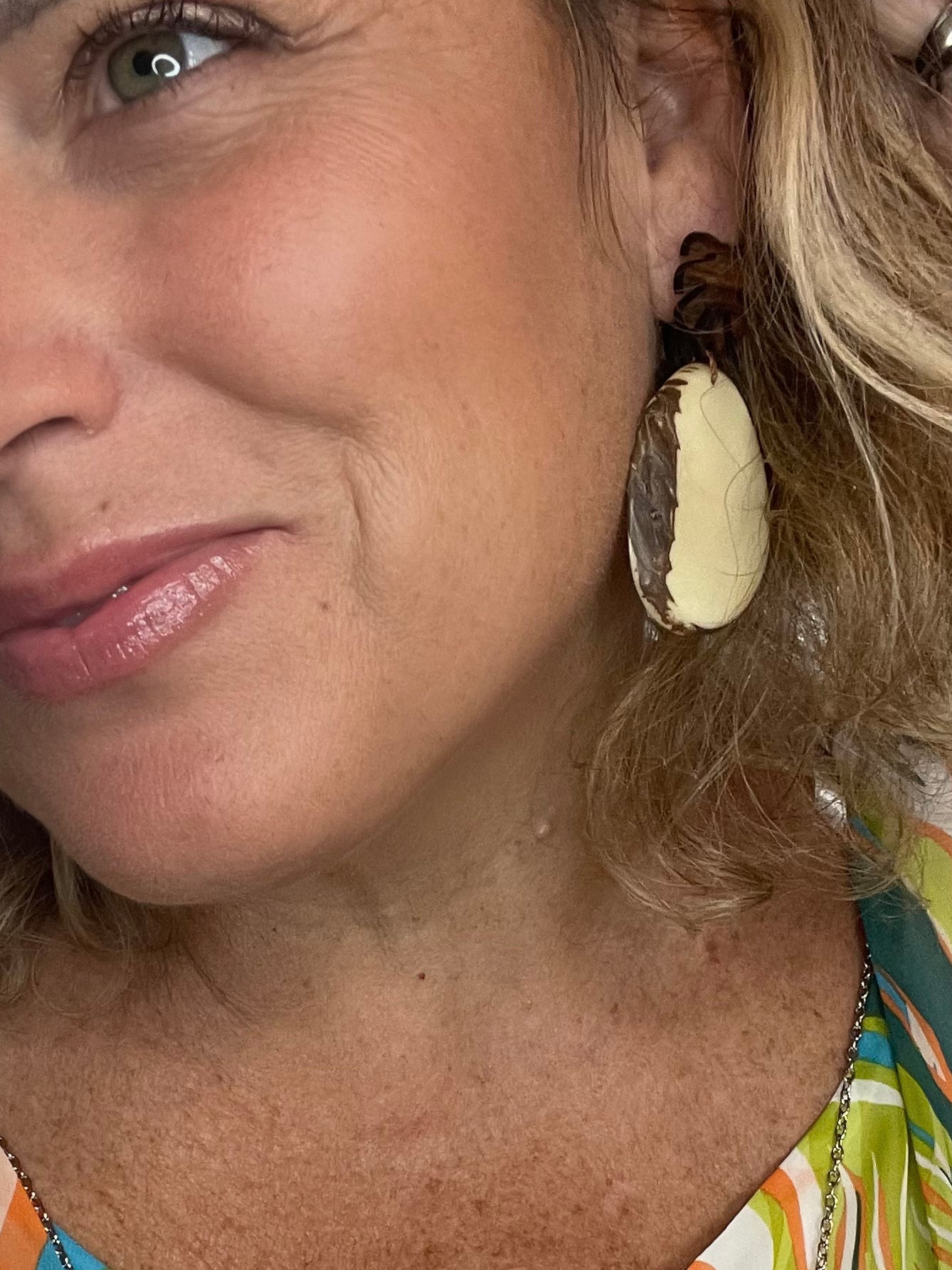 model in Tagua Earrings solid colorful tagua and wood monstera leaf design top with post earrings. tagua from Ecuador, made by artisans in Ecuador. Ecuador tagua jewelry. tropical earrings Tera